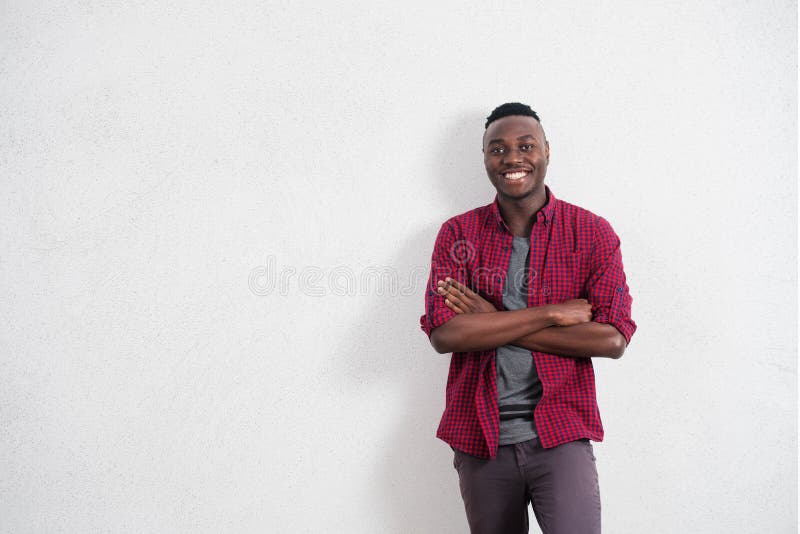 Gente y concepto de la forma de vida Retrato del varón africano joven feliz y positivo en buen humor, camisa roja que lleva imagen de archivo Gente y concepto de la forma de vida Retrato del varón africano joven feliz y positivo en buen humor, camisa roja que lleva imagen de archivo