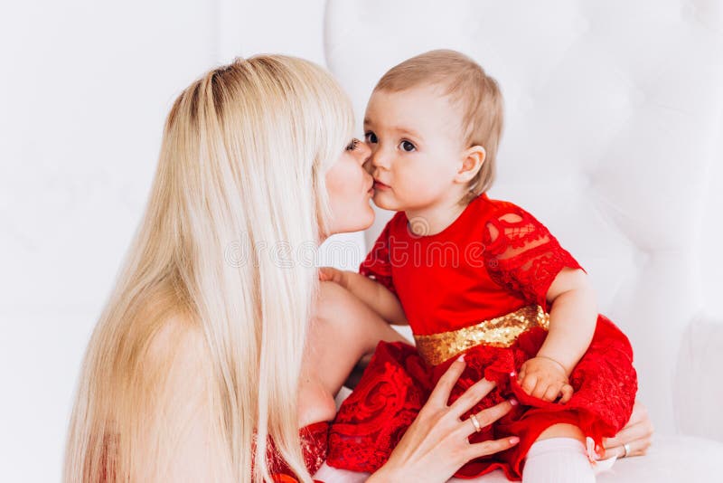 Gentil, famille, bonne photo de m?re et fille dans des robes rouges dans le studio Le jour et les filles de m?re photo libre de droits Gentil, famille, bonne photo de m?re et fille dans des robes rouges dans le studio Le jour et les filles de m?re photo libre de droits
