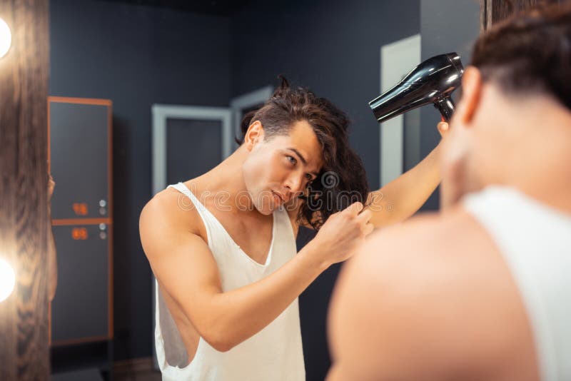 Gentil jeune homme attirant touchant ses cheveux photos libres de droits Gentil jeune homme attirant touchant ses cheveux photos libres de droits