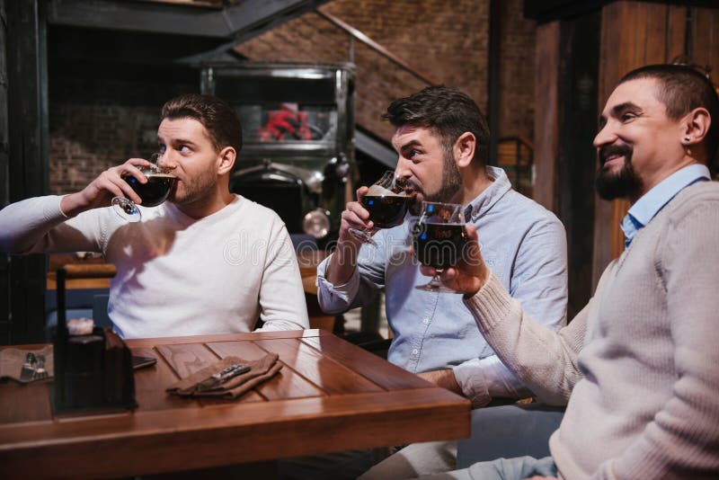 Gentils hommes avec plaisir ayant la bière image stock Gentils hommes avec plaisir ayant la bière image stock