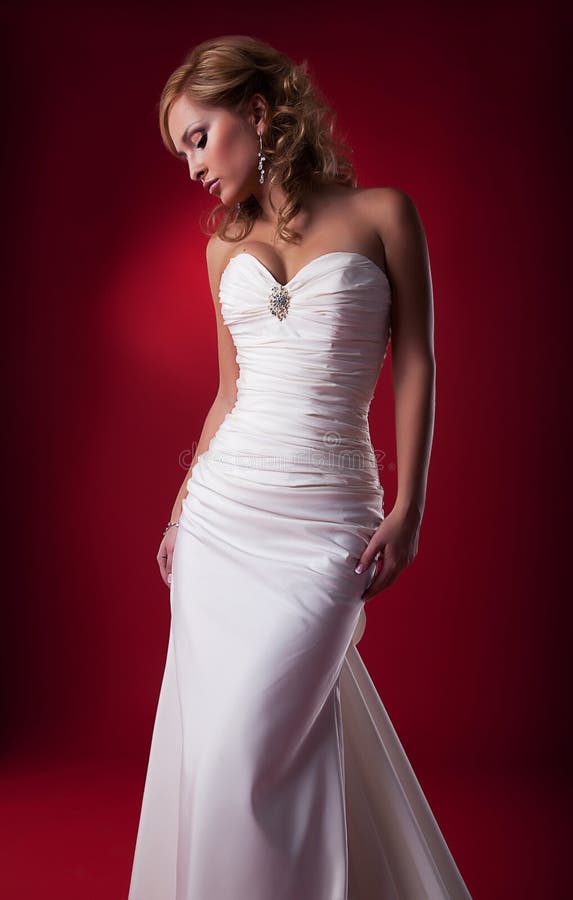 Gentle cute blonde bride posing in studio