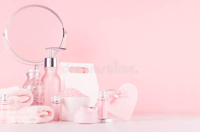 Gentle girlish dressing table with round mirror and cosmetics products - rose oil, bath salt, cream, perfume, cotton towel.