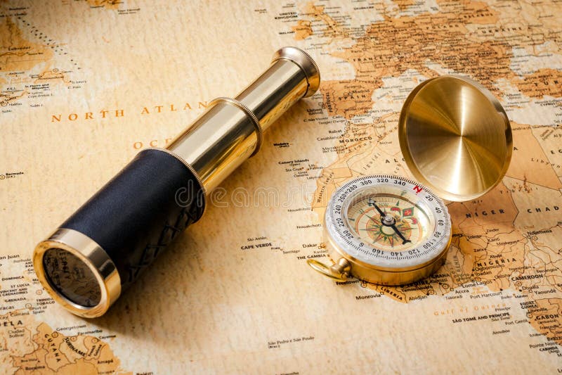 Geography, navigation and traveling concept with vintage compass, antique brass telescope or spyglass and old orange and map. Geography, navigation and traveling concept with vintage compass, antique brass telescope or spyglass and old orange and map