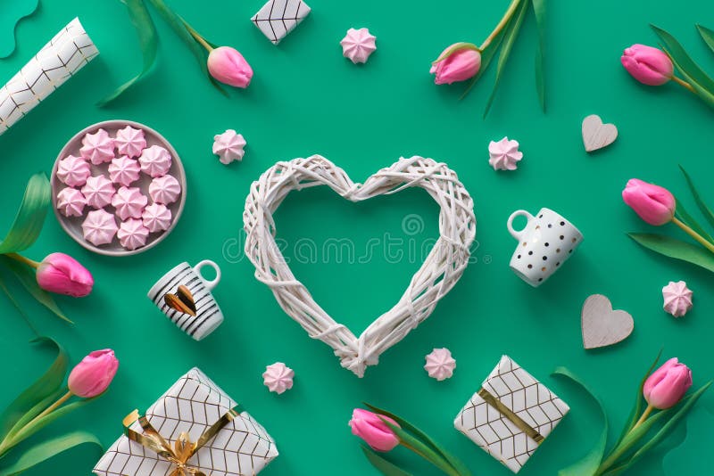 Geometric Valentine flat lay with Valentine`s date February 14 on calendar, flowers, gifts, hearts, pink marshmallows and coffee