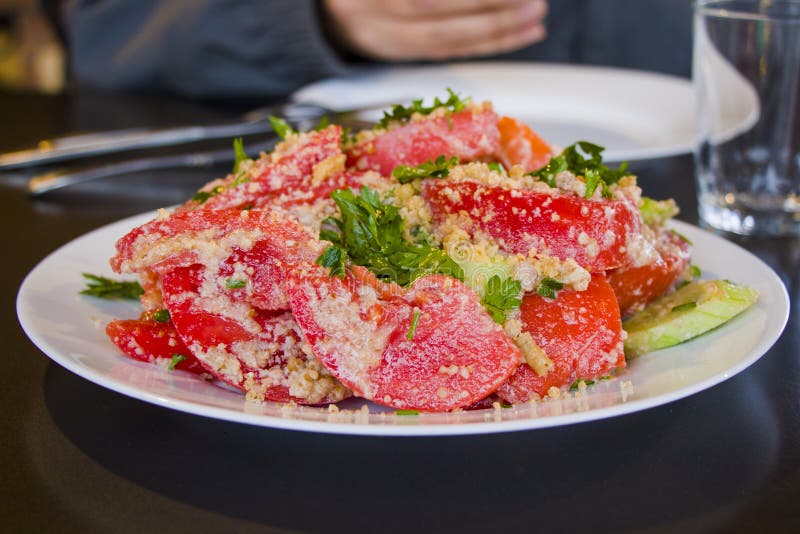 Georgian salad with tomatoes, cucumber, greens and walnut souse