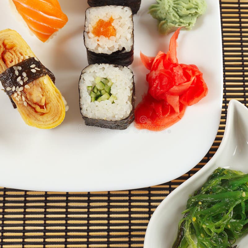 Geplaatste sushi en hiyashi wakame salade op bamboemat Mening van hierboven stock foto Geplaatste sushi en hiyashi wakame salade op bamboemat Mening van hierboven stock foto