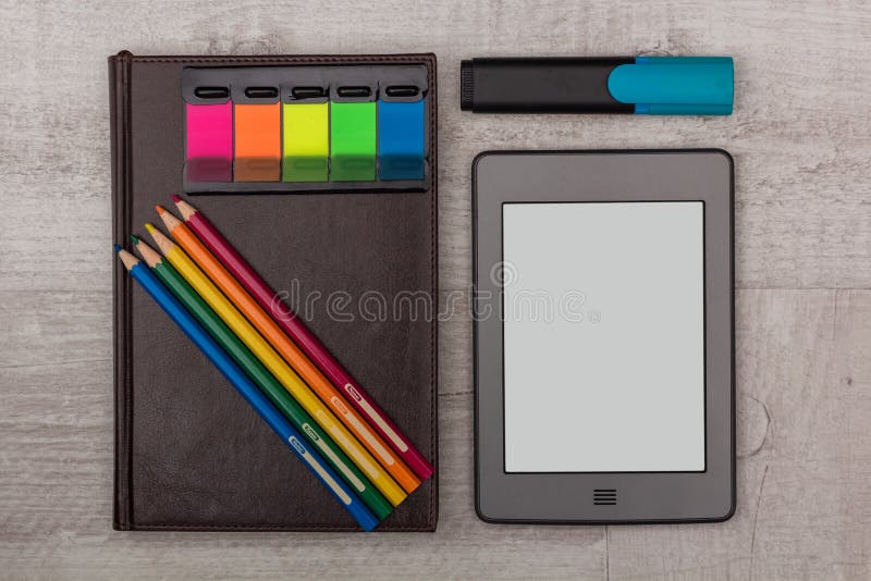 Geplaatste zaken: agenda, een eBook met kleurpotloden en teller stock afbeelding Geplaatste zaken: agenda, een eBook met kleurpotloden en teller stock afbeelding