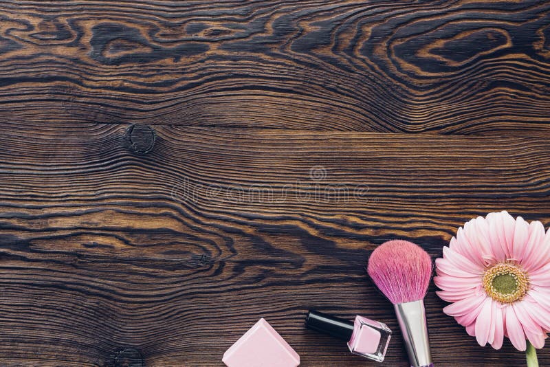 Gerbera rosa, spazzola di trucco, smalto su fondo di legno, vista superiore Spazio per testo fotografia stock Gerbera rosa, spazzola di trucco, smalto su fondo di legno, vista superiore Spazio per testo fotografia stock