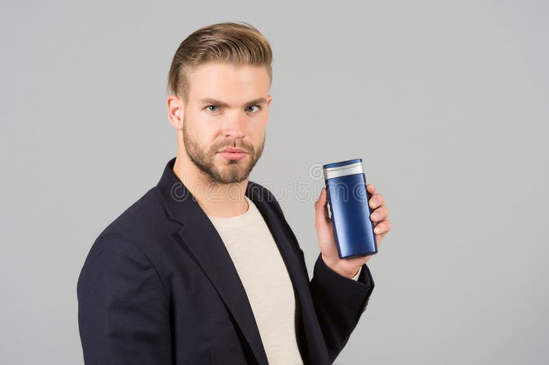 Gerente com a garrafa do champô ou do gel à disposição Homem farpado com cabelo à moda ou corte de cabelo Cosmético para o banho imagens de stock royalty free Gerente com a garrafa do champô ou do gel à disposição Homem farpado com cabelo à moda ou corte de cabelo Cosmético para o banho imagens de stock royalty free