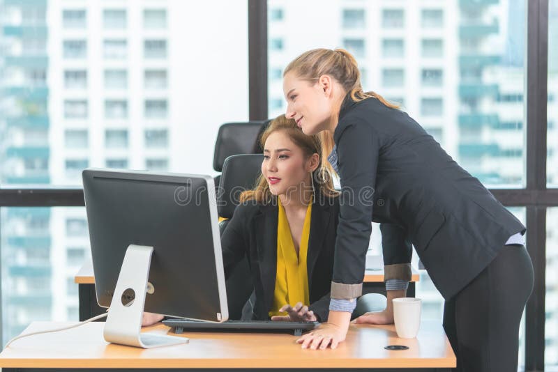 Gerente de Mulheres Chefe ajudando e ensinando seu oficial no escritório fotos de stock Gerente de Mulheres Chefe ajudando e ensinando seu oficial no escritório fotos de stock
