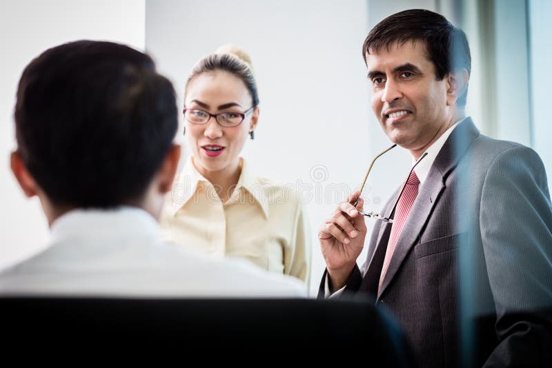 Gerente executivo que fala com os empregados sobre o projeto do negócio foto de stock royalty free Gerente executivo que fala com os empregados sobre o projeto do negócio foto de stock royalty free