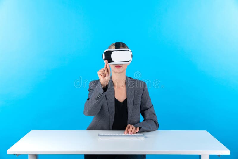 Smart manager wearing VR glasses while sitting at table with keyboard. Businesswoman pointing to manage data analysis while using suit and visual reality headset and enter in metaverse. Contraption. Smart manager wearing VR glasses while sitting at table with keyboard. Businesswoman pointing to manage data analysis while using suit and visual reality headset and enter in metaverse. Contraption.