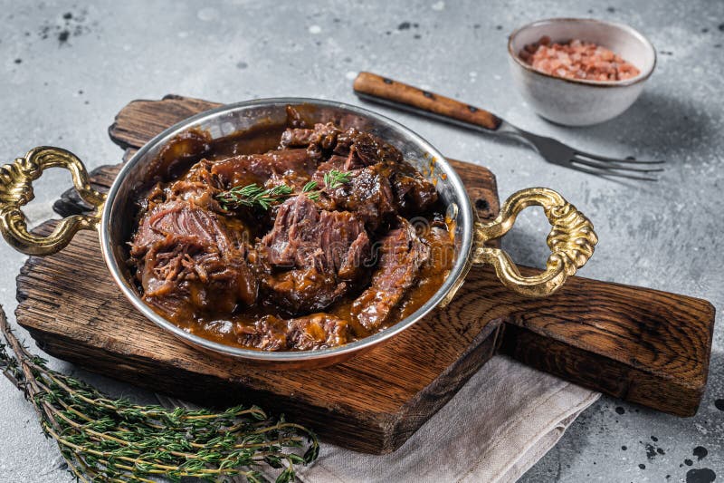 German Braised Beef Cheeks in Brown Red Wine Sauce. Gray Background