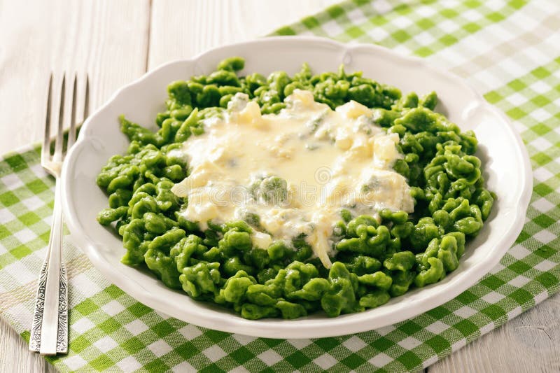 German Dumplings Spaetzle with Spinach and Cheese Sauce. Stock Photo