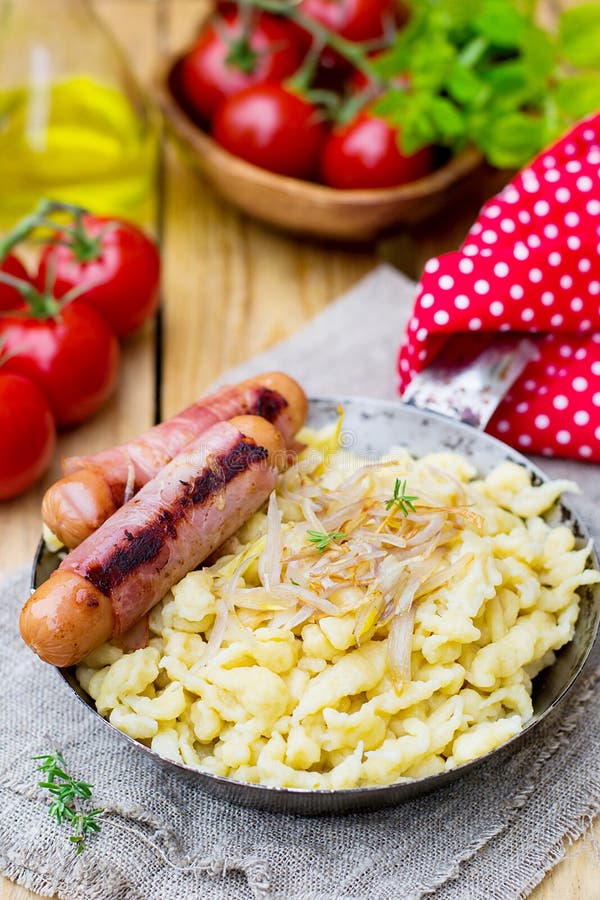 German Noodles Spatzle with Fried Onions and Sausages Stock Photo