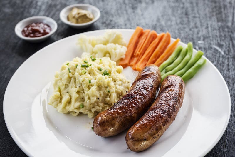 German Sausage with Mashed Potato and Vegetables Meal Stock Photo