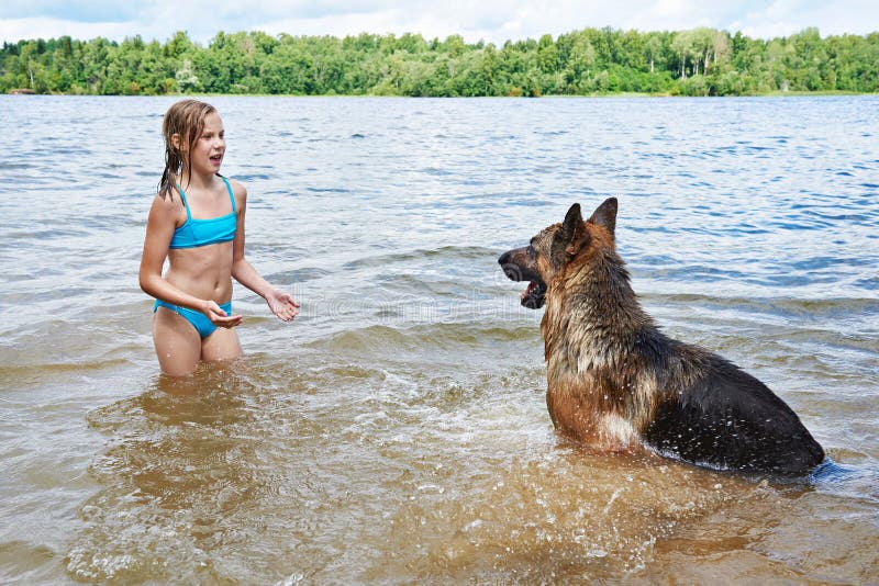 German shepherd and girl playing in lake