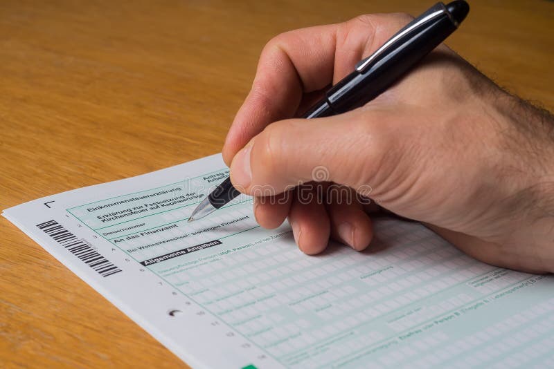 German Tax Form Men Filling in German Tax Form with Black Pen