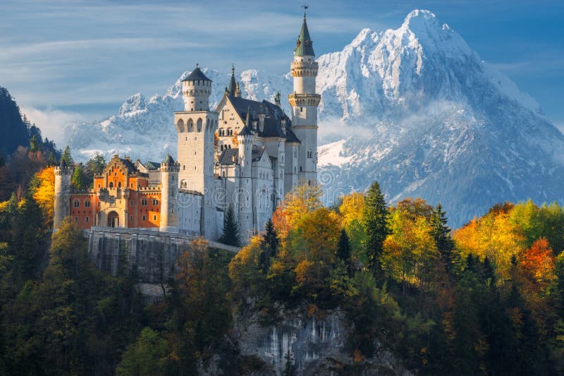 germany Castello famoso del Neuschwanstein nei precedenti delle montagne e degli alberi nevosi con giallo e le foglie verdi immagine stock libera da diritti germany Castello famoso del Neuschwanstein nei precedenti delle montagne e degli alberi nevosi con giallo e le foglie verdi immagine stock libera da diritti