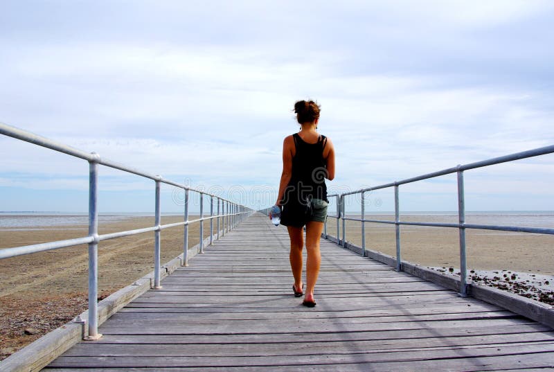 A woman walking along the longest jetty in Australia (and one of the longest in the world, at over 1500m long), at Port Germein - low tide. A woman walking along the longest jetty in Australia (and one of the longest in the world, at over 1500m long), at Port Germein - low tide.