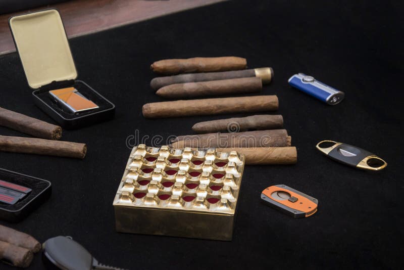 Group of rolled tobacco cigars with ash tray and cutters. Group of rolled tobacco cigars with ash tray and cutters