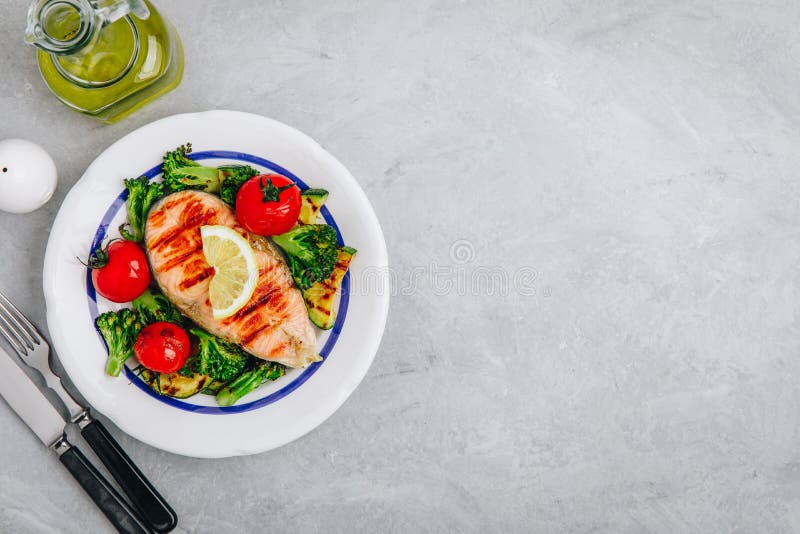 Geroosterd zalmlapje vlees en gebakken groenten Tomaat, broccoli, courgette met zalmfilet Hoogste mening royalty-vrije stock afbeelding Geroosterd zalmlapje vlees en gebakken groenten Tomaat, broccoli, courgette met zalmfilet Hoogste mening royalty-vrije stock afbeelding