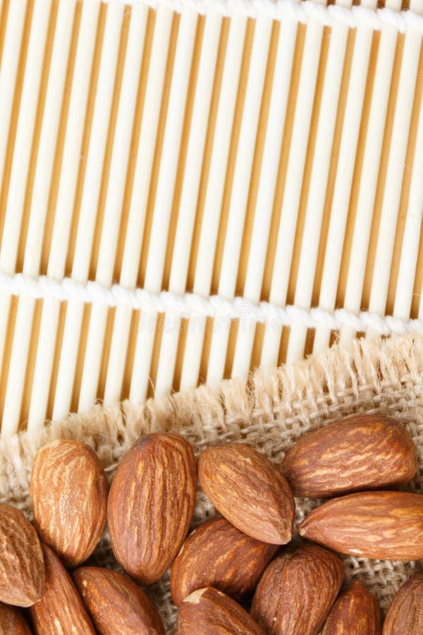 Geroosterde die amandelen op jute op een houten lijst wordt geplaatst royalty-vrije stock afbeeldingen Geroosterde die amandelen op jute op een houten lijst wordt geplaatst royalty-vrije stock afbeeldingen