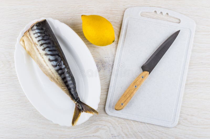 Geräucherte Makrele im Teller, in der Zitrone und im Messer auf Schneidebrett lizenzfreies stockfoto Geräucherte Makrele im Teller, in der Zitrone und im Messer auf Schneidebrett lizenzfreies stockfoto