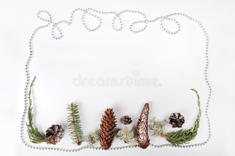 Christmas border of silver ball chain, spruce cones, pine cones, juniper and spruce twigs. Copy space in upper middle part of image. Christmas border of silver ball chain, spruce cones, pine cones, juniper and spruce twigs. Copy space in upper middle part of image.