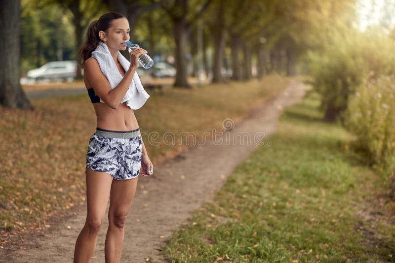 Geschikt sportief vrouwen drinkwater van een plastic fles royalty-vrije stock fotografie Geschikt sportief vrouwen drinkwater van een plastic fles royalty-vrije stock fotografie