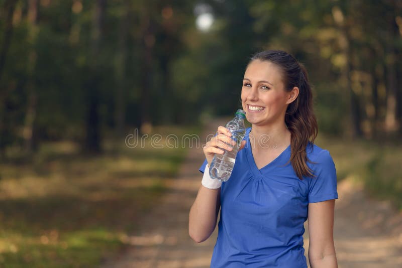Geschikte jonge vrouw die gebotteld water drinken royalty-vrije stock afbeelding Geschikte jonge vrouw die gebotteld water drinken royalty-vrije stock afbeelding