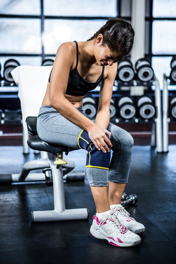 Fit woman having knees pain at gym. Fit woman having knees pain at gym