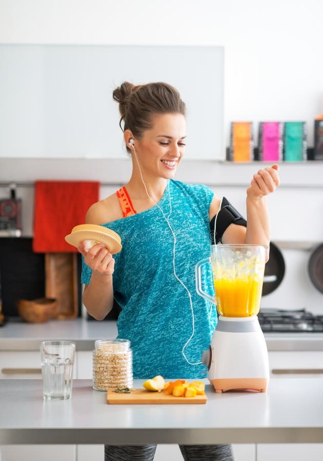 Geschiktheidsvrouw die pompoen smoothie in keuken maken stock foto's Geschiktheidsvrouw die pompoen smoothie in keuken maken stock foto's