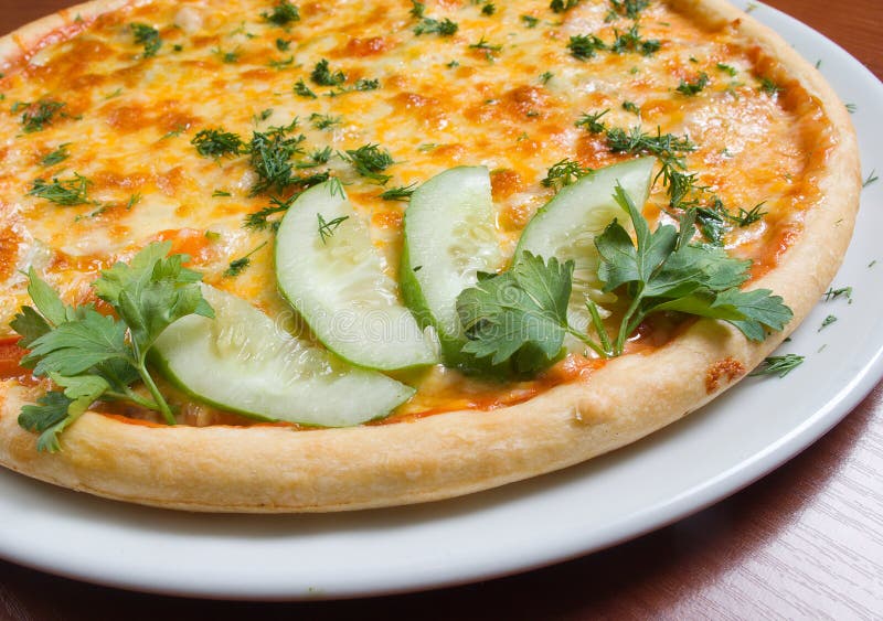 Geschmackvolle italienische Pizza mit gewordener kühler Gurke stockbild Geschmackvolle italienische Pizza mit gewordener kühler Gurke stockbild