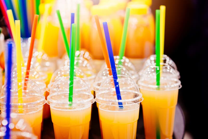 Geschmackvoller kalter Orangensaft in der Plastikschale stockfotografie Geschmackvoller kalter Orangensaft in der Plastikschale stockfotografie