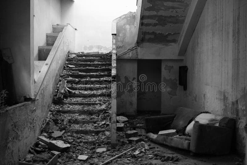 An old and snatched sofa near destroyed stairs in an old office. An old and snatched sofa near destroyed stairs in an old office.