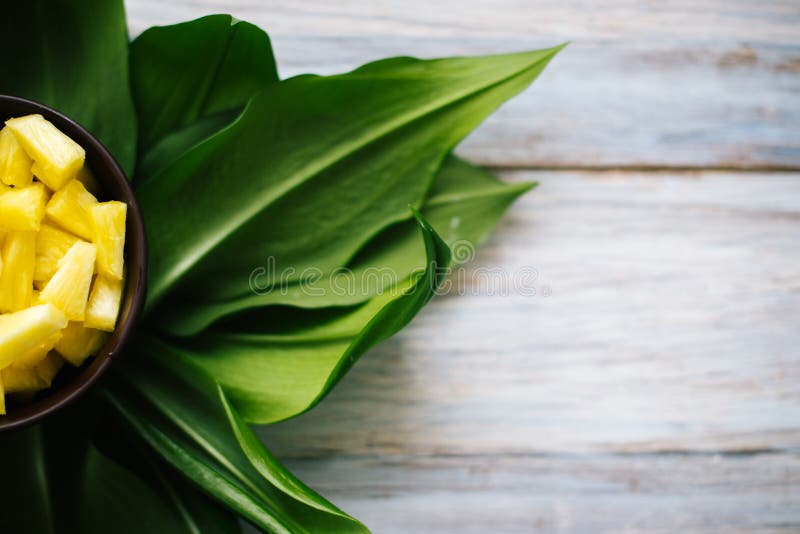 Geschnittene frische Ananas in einer Schüssel auf den Blättern stockfotos Geschnittene frische Ananas in einer Schüssel auf den Blättern stockfotos