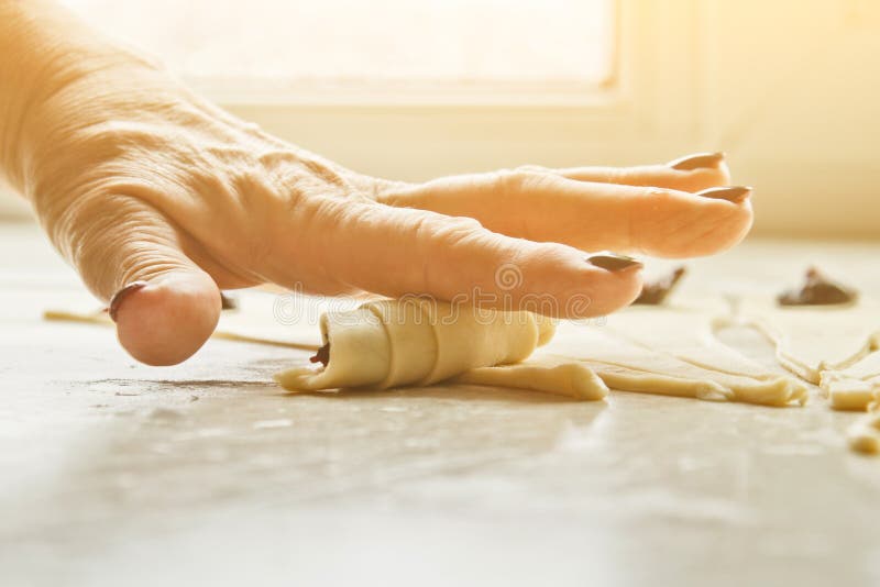 Geschnittener roher Mischteig mit Beeren liegt auf dem Backblech Kochen der Backform die H?nde der Frauen rollen den Teig auf ein stockbild Geschnittener roher Mischteig mit Beeren liegt auf dem Backblech Kochen der Backform die H?nde der Frauen rollen den Teig auf ein stockbild
