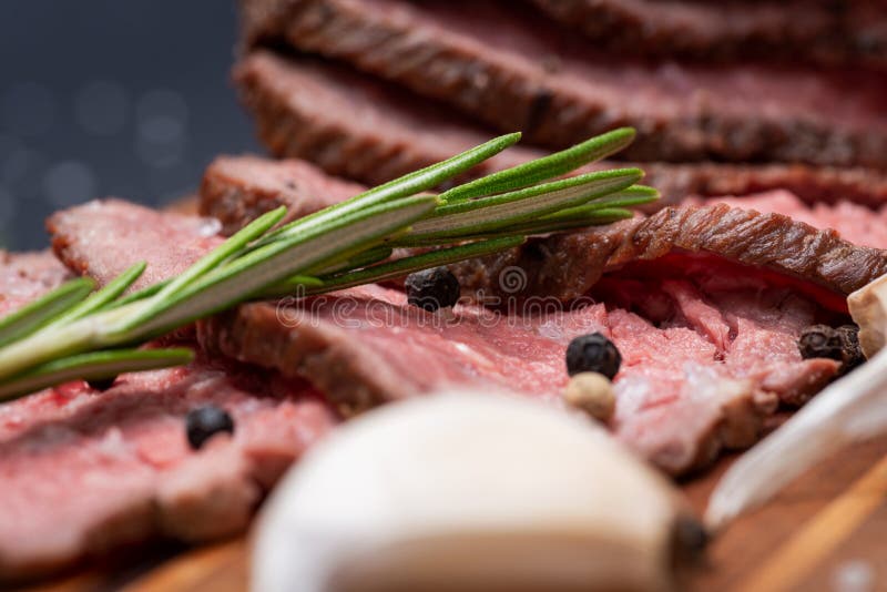 Geschnittenes bäuerisches saftiges Mais-Roastbeef geschmückt mit Tomaten, frischen Rosemary Herb-, Knoblauch-und Regenbogen-Pfeff stockbild Geschnittenes bäuerisches saftiges Mais-Roastbeef geschmückt mit Tomaten, frischen Rosemary Herb-, Knoblauch-und Regenbogen-Pfeff stockbild