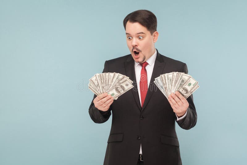 Geschokte bedrijfsmens verrast en holding vele dollars royalty-vrije stock afbeeldingen Geschokte bedrijfsmens verrast en holding vele dollars royalty-vrije stock afbeeldingen