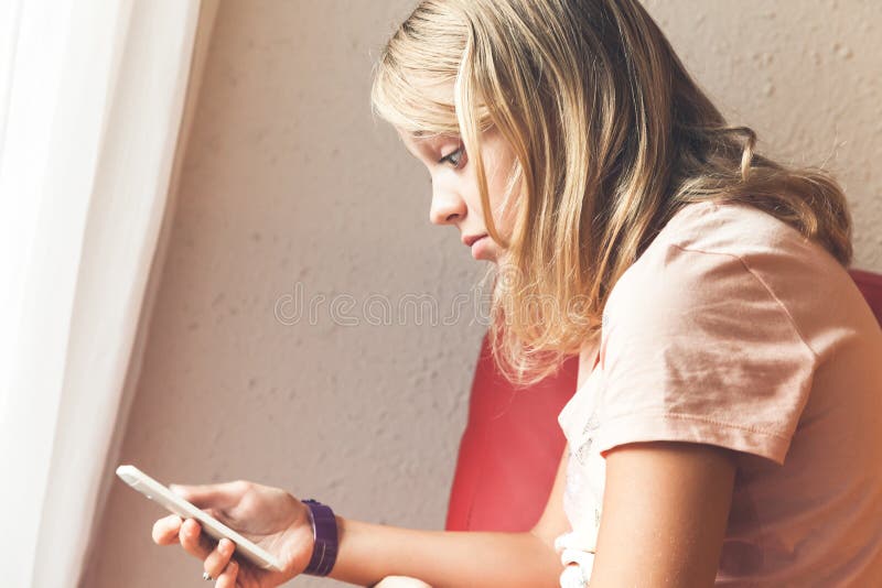 Geschokte blonde tiener met smartphone royalty-vrije stock afbeeldingen Geschokte blonde tiener met smartphone royalty-vrije stock afbeeldingen