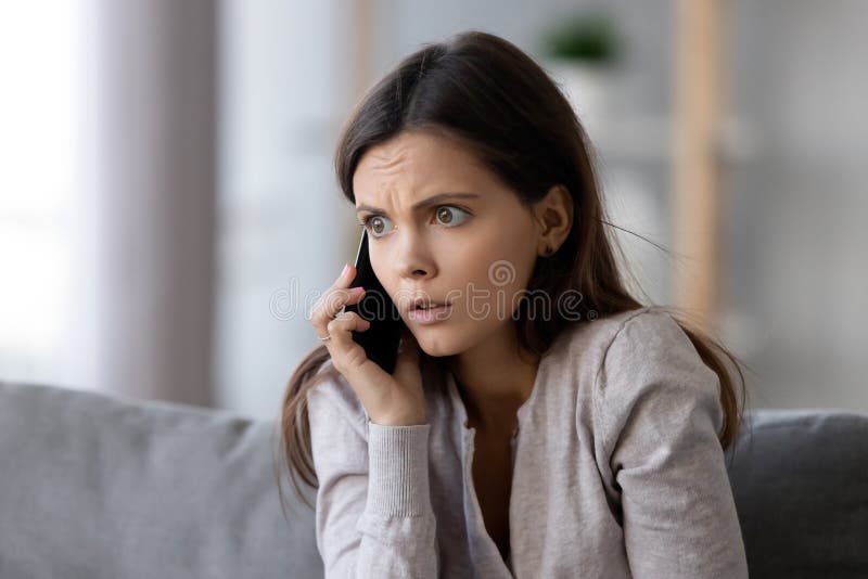 Geschokte of doen schrikken jonge vrouw die op mobiele telefoon spreken royalty-vrije stock foto's Geschokte of doen schrikken jonge vrouw die op mobiele telefoon spreken royalty-vrije stock foto's