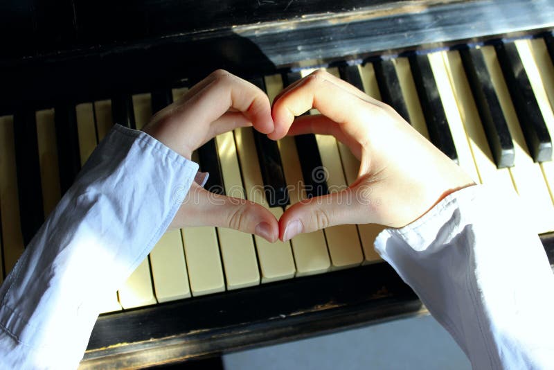 Geschoten van Niet identificeerbare Vrouwelijke Handen die een Hartvorm over een Piano maken royalty-vrije stock foto's Geschoten van Niet identificeerbare Vrouwelijke Handen die een Hartvorm over een Piano maken royalty-vrije stock foto's