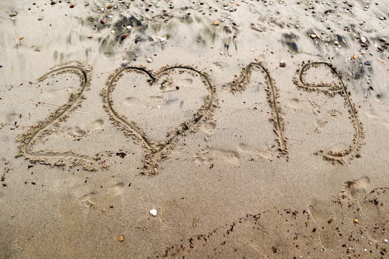 2019 geschreven op het overzeese zand met hart gestalte gegeven nummer 0 stock foto 2019 geschreven op het overzeese zand met hart gestalte gegeven nummer 0 stock foto