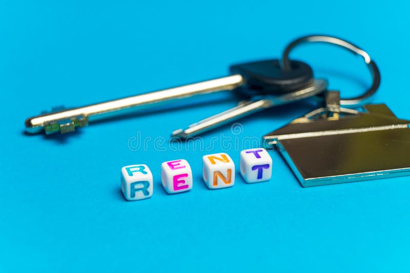 Geschriebene farbige Würfel der Aufschrift Miete Foto auf dem Hintergrund einer Schlüssel-UHRKETTE in Form eines Hauses lizenzfreie stockfotos Geschriebene farbige Würfel der Aufschrift Miete Foto auf dem Hintergrund einer Schlüssel-UHRKETTE in Form eines Hauses lizenzfreie stockfotos