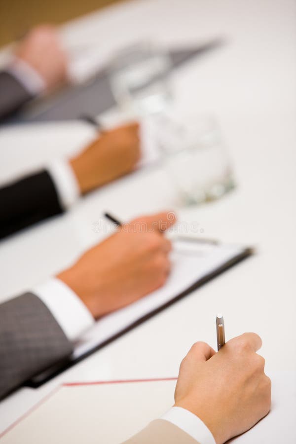 Image of human hands with pens over business documents. Image of human hands with pens over business documents