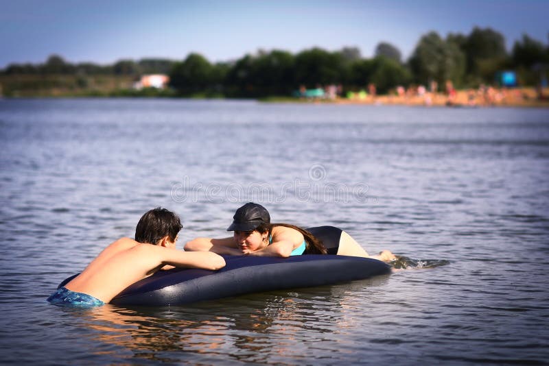 Geschwister Bruder und Schwester mit aufblasbaren matrass schwimmen im See auf Sandstrandhintergrund stockfoto Geschwister Bruder und Schwester mit aufblasbaren matrass schwimmen im See auf Sandstrandhintergrund stockfoto