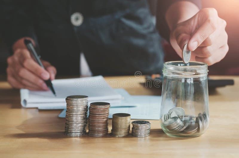Geschäft accountin mit Einsparungsgeld mit der Hand, die herein Münzen setzt lizenzfreies stockfoto Geschäft accountin mit Einsparungsgeld mit der Hand, die herein Münzen setzt lizenzfreies stockfoto