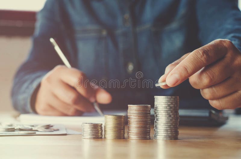 Geschäft accountin mit Einsparungsgeld mit der Hand, die an Münzen setzt lizenzfreies stockbild Geschäft accountin mit Einsparungsgeld mit der Hand, die an Münzen setzt lizenzfreies stockbild
