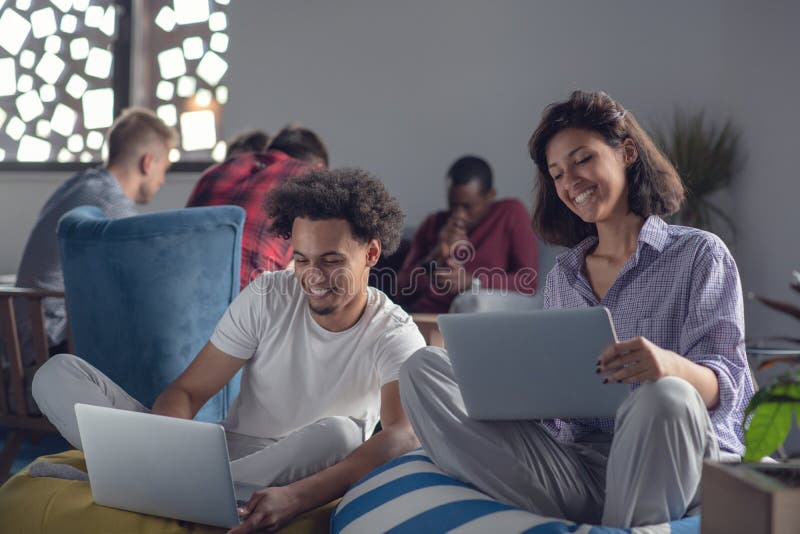 Geschäft, Start, Technologie und Leutekonzept - glückliches internationales kreatives Team mit Laptop- und Tabletten-PC-Computer stockfotografie